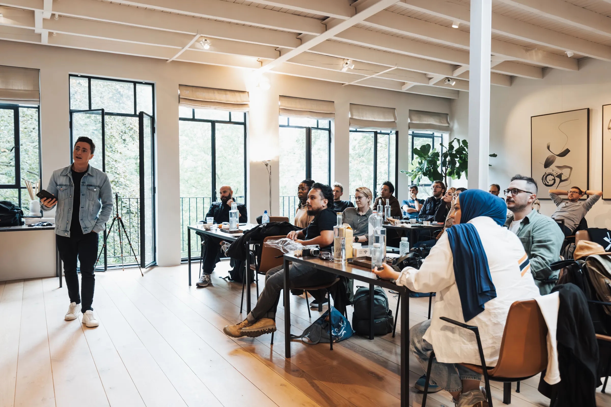 Een trainer geeft een presentatie aan een groep in een lichte zaal