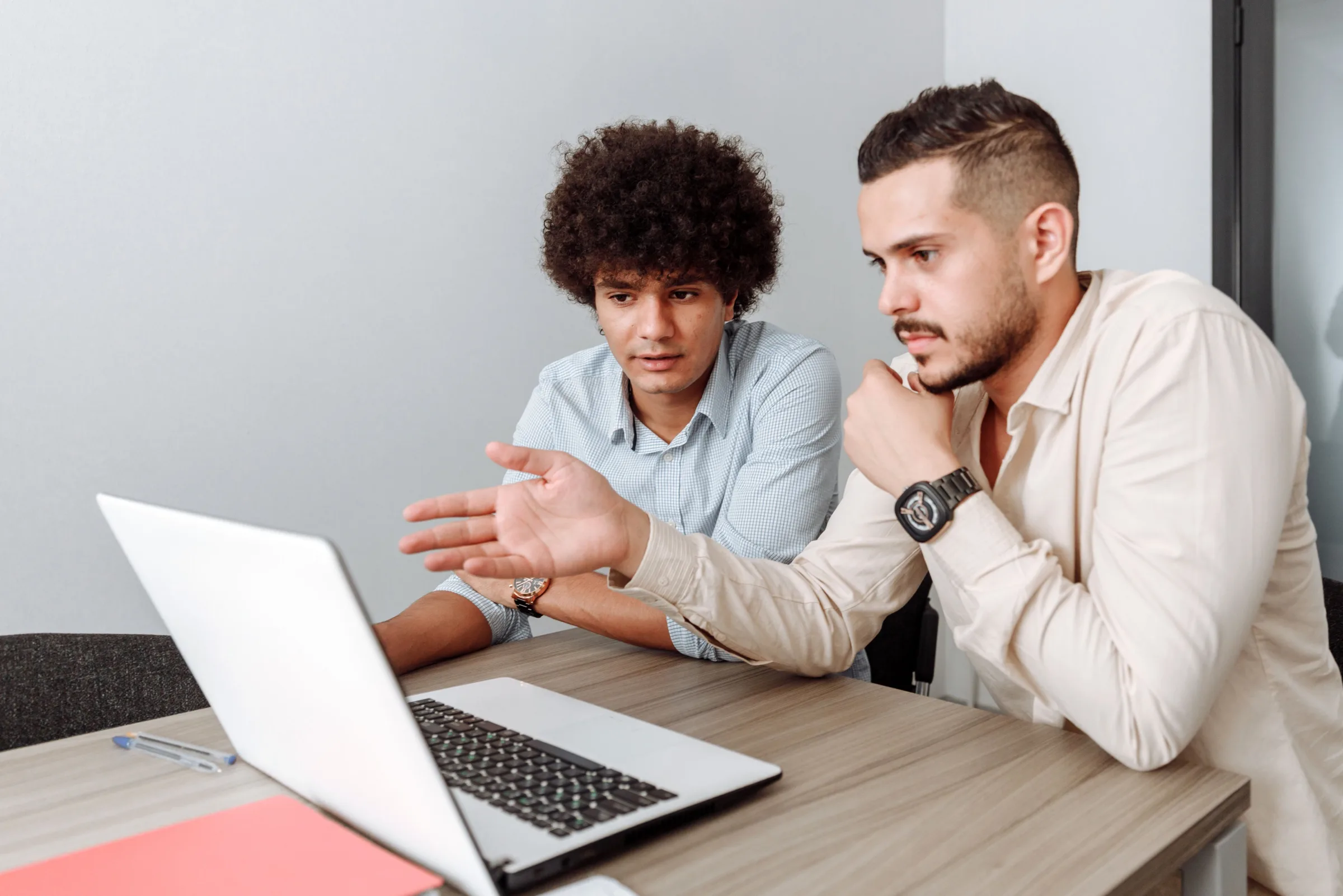 Twee collega's bespreken samen iets op een laptop aan een vergadertafel