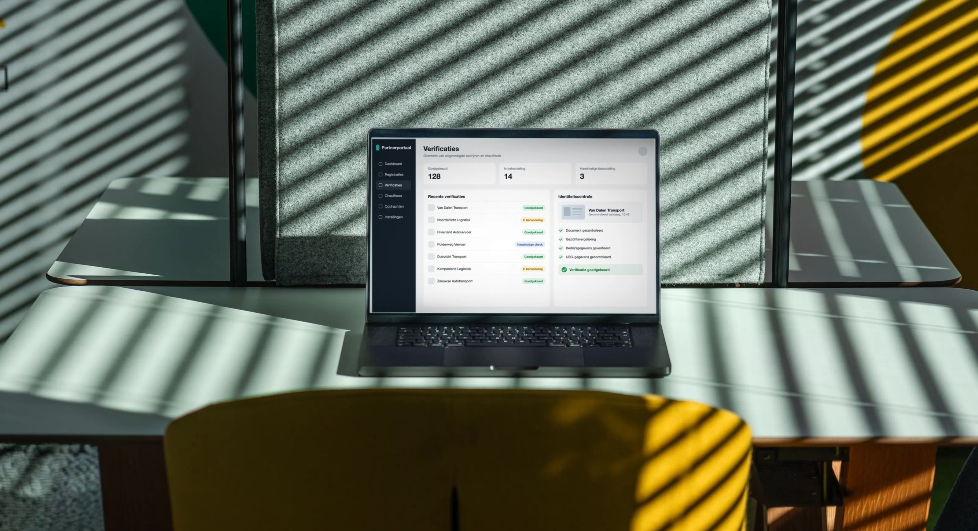 Laptop op een bureau in een zonnig kantoor, met een verificatiedashboard waarin een identiteitscontrole is goedgekeurd