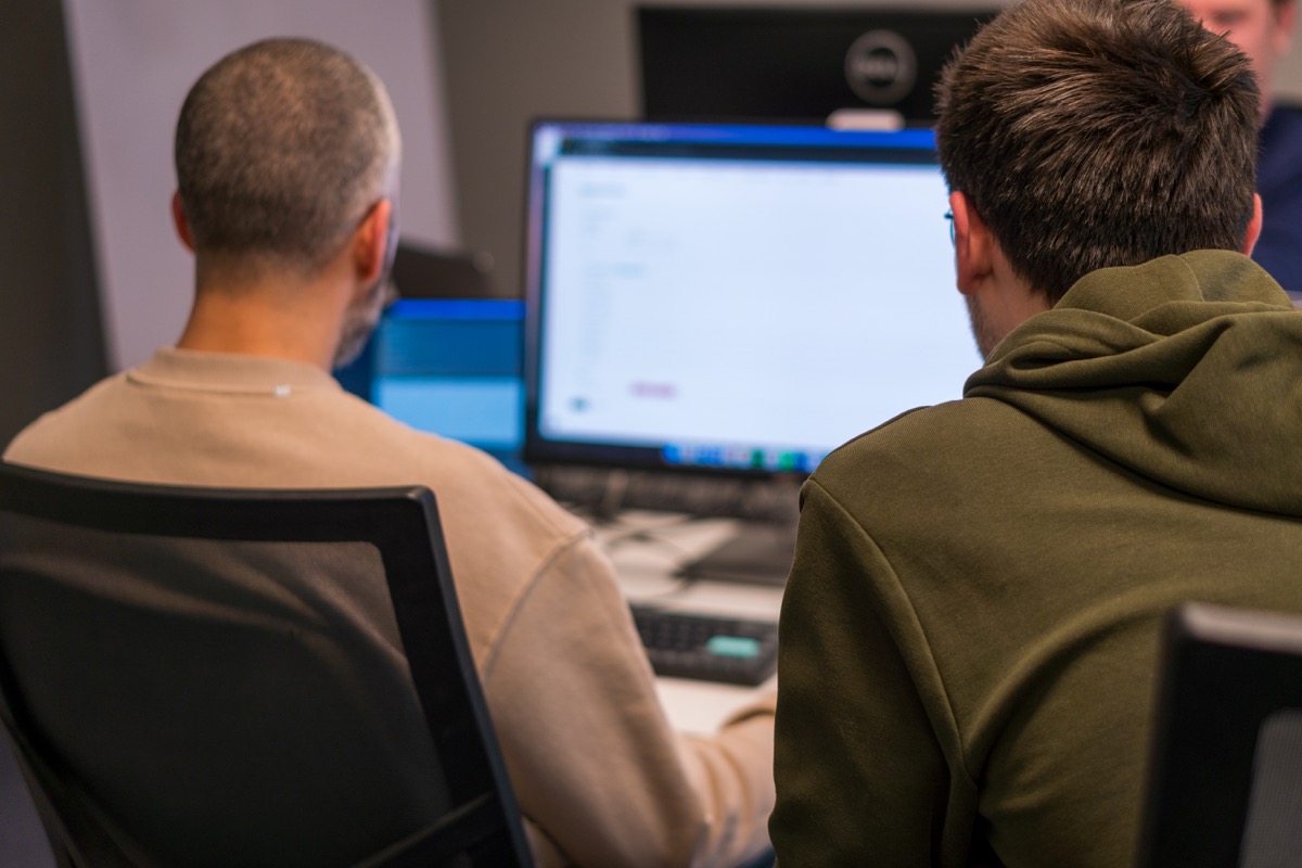 Medewerkers van JAM-IT in gesprek op kantoor over softwareontwikkeling en tijdelijke Mendix-capaciteit.
